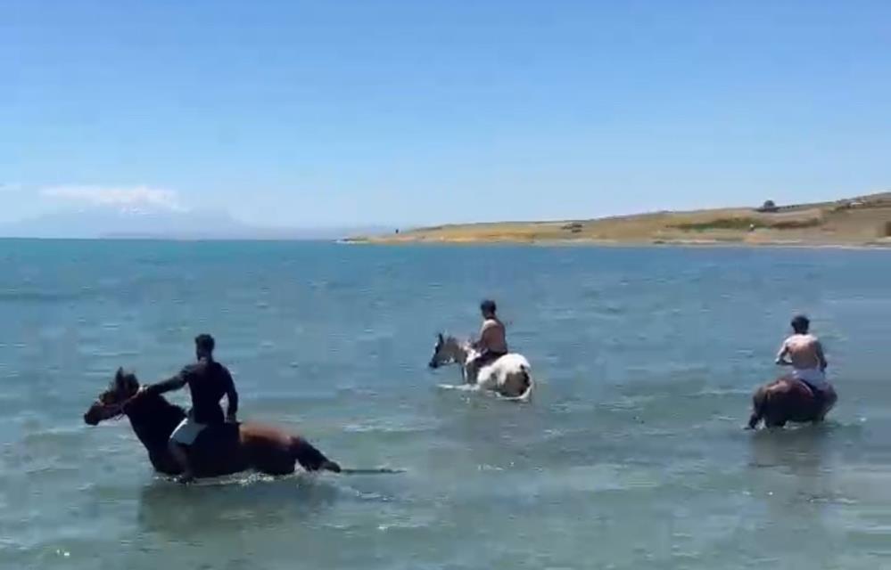Sıcaktan bunalan gençler atlarıyla Van Gölü’nde serinledi